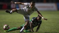 Gelandang Persebaya, Abu Rizal Maulana, menghindari tekel gelandang PSMS, Frets Butuan, pada laga final di Stadion GBLA, Bandung, Selasa (28/11/2017). Persebaya menang 3-2 atas PSMS. (Bola.com/Vitalis Yogi Trisna)