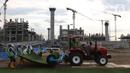 Pekerja melakukan pemasangan rumput di lapangan latih Jakarta International Stadium, Jumat (23/10/2020). Nantinya lapangan latihan ini akan ditumbuhi rumput hybrid, yang memiliki komposisi 5 persen rumput sintetis dan 95 persen natural berjenis Zoysia Matrella. (Liputan6.com/Helmi Fithriansyah)