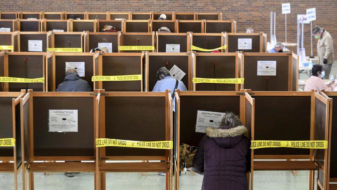 Para pemilih memberikan suara mereka di St. Elizabeth of Hungary Parish Center di North Adams, Massachusetts, Selasa (3/11/2020). (Gillian Jones/The Berkshire Eagle via AP)