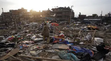 Warga mencari barang yang masih bisa terpakai di tempat pengungsian korban gempa bumi di Chuchepati, Kathmandu, Nepal, Selasa (14/3). Pemerintah Nepal terpaksa menggusur kamp ini karena dianggap sudah terlalu lama. (AP Photo)