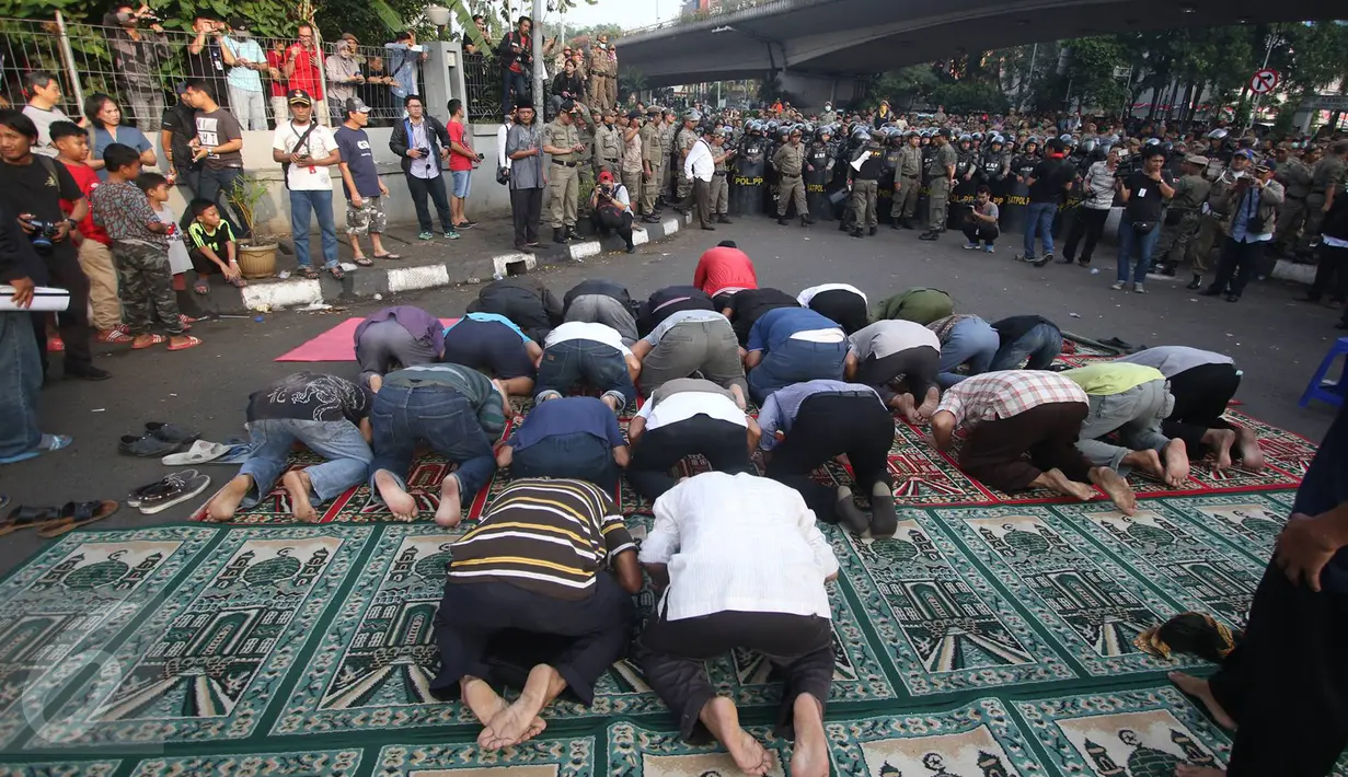 Belasan warga menggelar salat duha di tengah jalan jelang penggusuran rumah di kawasan Rawajati, Pancoran, Kamis (9/1). Hal itu dilakukan warga yang berharap pembongkaran tidak jadi dilakukan Pemkot Jakarta Selatan. (Liputan6.com/Immanuel Antonius)
