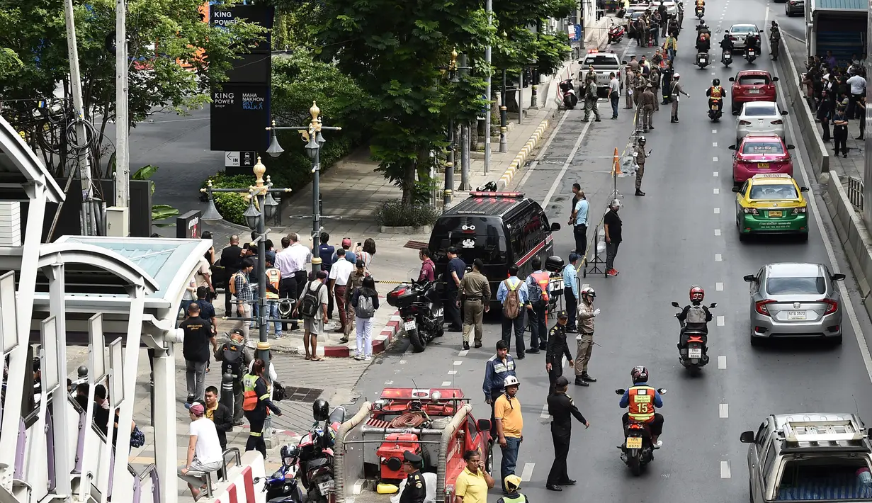 Sejumlah warga dan polisi berkumpul di lokasi ledakan di Bangkok (2/8/2019). Sedikitnya ada lima lokasi atau titik ledakan. Seperti di bawah halte BTS (Bangkok Sky Train) Chong Nonsi, persimpangan 57/1 Jalan Rama IX. (AFP Photo/Lillian Suwanrumpha)