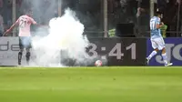 Antonio Candreva gelandang Lazio bermain di antara asap dan api yang memenuhi stadion Renzo Barbera kandang Palermo, Minggu (11/4/2016).