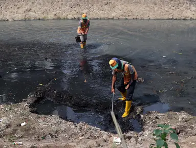 Pekerja dari UPK Badan Air Dinas Kebersihan DKI Jakarta mencangkul endapan lumpur di salah satu sisi Kali Cideng kawasan Epicentrum Kuningan, Jakarta, Kamis (20/6/2019). Pencangkulan ini untuk menghilangkan endapan lumpur dan memperlancar arus air. (Liputan6.com/Helmi Fithriansyah)