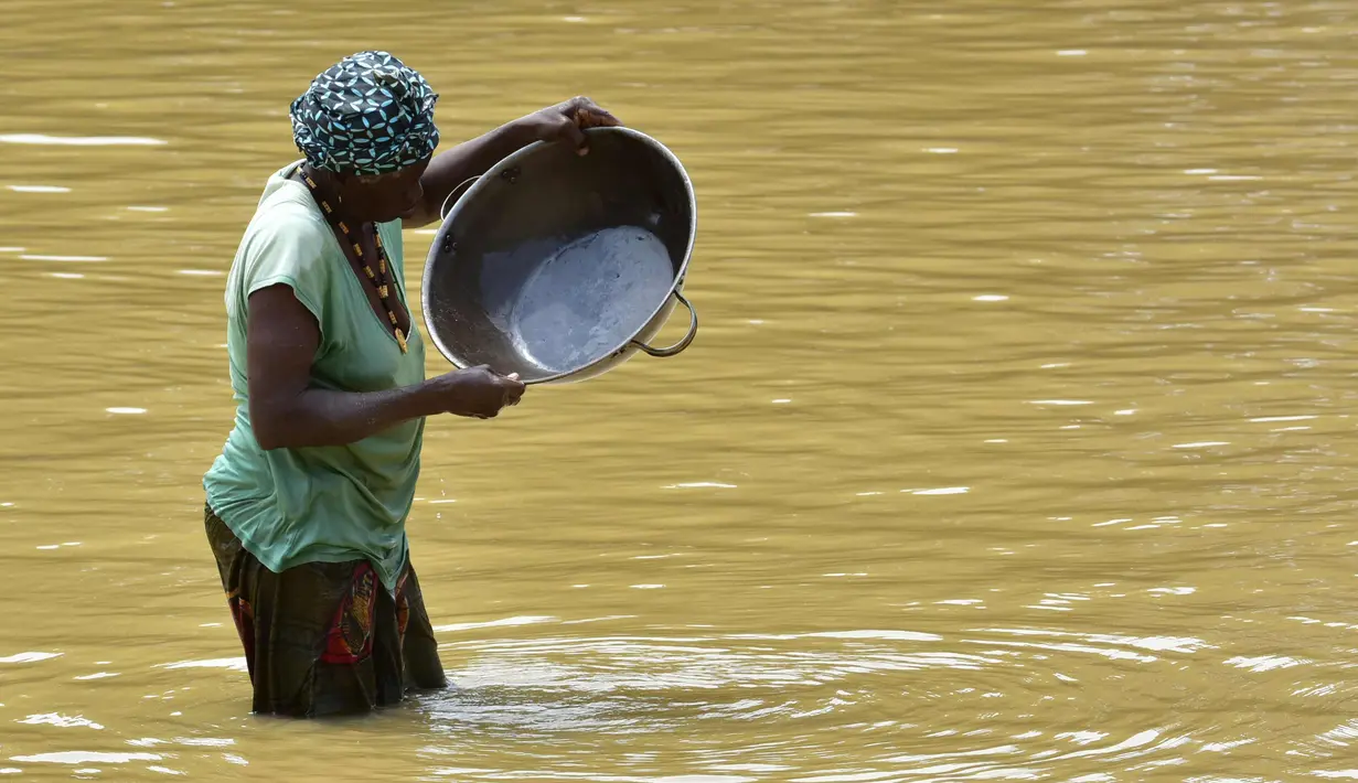 Penambang emas wanita bekerja di sungai Pampana di dekat Mekeni, Sierra Leone (5/3). Menjelang pemilihan umum di Sierra Leone, penambang berharap dari partai yang menang di pemerintahan baru agar mencari nafkah di Magburaka. (AFP Photo/Issouf Sanogo)