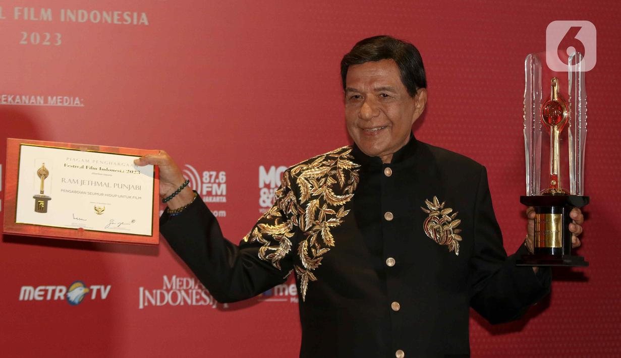 Produser Raam Punjabi berpose memegang piala saat menerima Anugerah Festival Film Indonesia (FFI) 2023 kategori  Pengabdian Seumur Hidup di Ciputra Artpreneur, Jakarta, Selasa (14/11/2023). (Liputan6.com/Herman Zakharia)