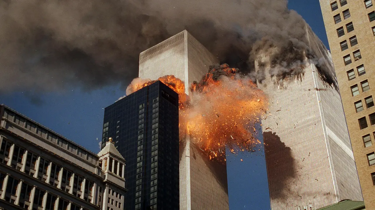 Asap mengepul dari salah satu menara World Trade Center saat api dan puing-puing meledak dari menara kedua (AP Photos/Chao Soi Cheong)