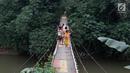 Warga melintasi jembatan penyeberangan buatan warga di kawasan Lenteng Agung, Jakarta, Rabu (24/5). Meskipun kondisinya memprihatinkan, warga setempat tetap menggunakan jembatan tersebut. (Liputan6.com/Immanuel Antonius)