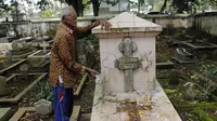 Mbah Mul, petugas makam menunjukkan salah satu makam yang dirusak. (foto: Liputan6.com / felek wahyu)