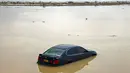 Kendaraan melewati jalan yang banjir setelah Topan tropis Shaheen di kota al-Mussanah di utara Oman (4/10/2021). Korban tewas akibat Topan Shaheen naik menjadi lebih dari 10 orang pada hari Senin sementara nelayan lain dari Iran masih hilang. (AFP/Mohammed Mahjoub)