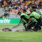 Petugas di Jakarta International Stadium (JIS) menguras lapangan yang tergenang akibat guyuran hujan deras jelang pertandingan Brasil Vs Argentina pada perempat final Piala Dunia U-17 2023, Jumat (24/11/2023). (Bola.com/Bagaskara Lazuardi)