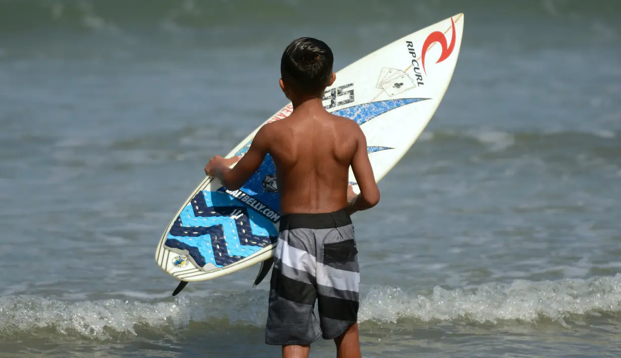Natan Bontje selama latihan di pantai Kuta dekat Denpasar di pulau resor Indonesia Bali (6/5). Natan berusia sembilan tahun merupakan peserta termuda yang mengikuti kompetisi Asian Surfing Tour 2018 yang telah berakhir. (AFP Photo/Sonny Tumbelaka)