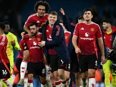 Pemain Manchester United, Bruno Fernandes (kedua kiri) bersama Joshua Zirkzee (tengah) dan Rasmus Hojlund (kedua kanan) melakukan selebrasi usai pertandingan sepak bola Liga Premier Inggris melawan Manchester City di Stadion Etihad, Manchester, Inggris, pada 15 Desember 2024. (Paul ELLIS/AFP)