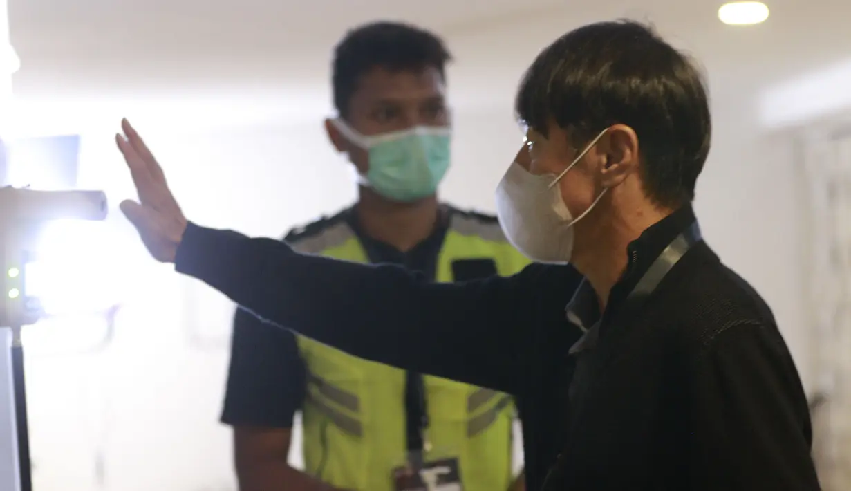 Pelatih Timnas Indonesia, Shin Tae-yong mengukur suhu tubuh saat tiba di Stadion Madya, Jakarta. (Foto: Bola.com/M. Iqbal Ichsan)