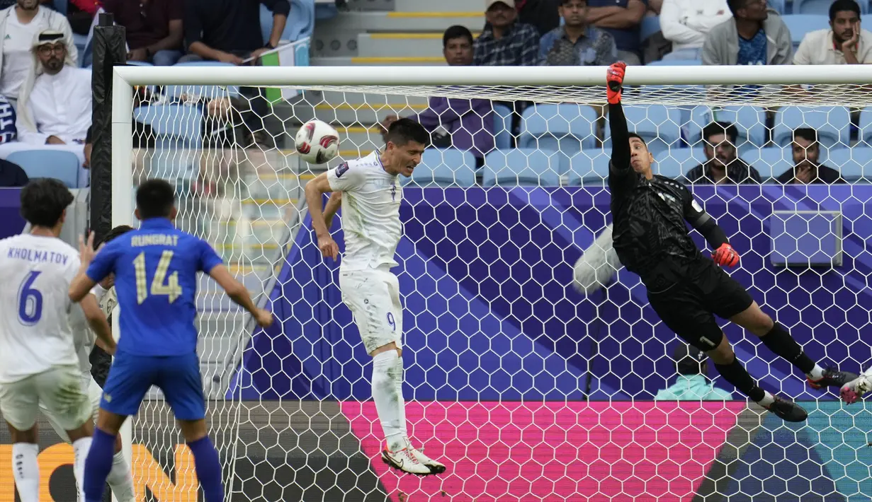 Kiper Timnas Uzbekistan, Utkir Yusupov dan bek Odiljon Xamrobekov (tengah) berusaha menghalau bola tendangan pemain Thailand pada laga babak 16 besar Piala Asia 2023 di Al Janoub Stadium, Al Wakrah, Qatar, Selasa (30/1/2024). (AP Photo/Aijaz Rahi)