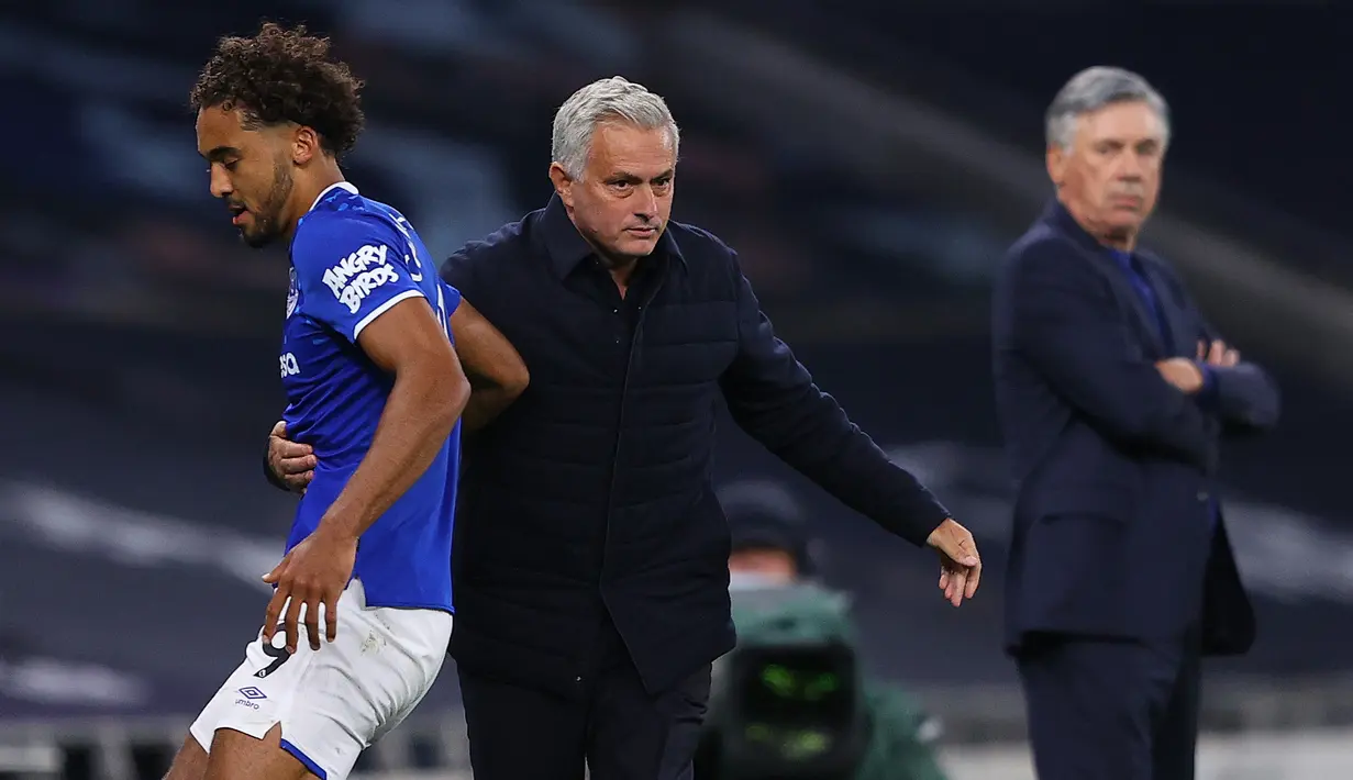 Pelatih Tottenham Hotspur, Jose Mourinho, dan pelatih Everton, Carlo Ancelotti, pada laga Premier League, Senin (6/7/2020). Mourinho rela langgar aturan jarak sosial demi memeluk Carlo Ancelotti. (AFP/Richard Heathcote)