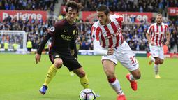 Gelandang Stoke, Ramadan Sobhi, berusaha melewati gelandang Manchester City, David Silva. City menguasai jalannya laga dengan penguasaan bola 58 persen. (AFP/Lindsey Parnaby)