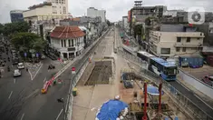 Transjakarta melintas dekat lokasi ditemukannya rel trem di lokasi pembangunan MRT Jakarta fase 2, Glodok, Jakarta, Selasa (28/12/2021). Rel trem itu ditemukan di bawah jalur TransJakarta di Jalan Pintu Besar Selatan pada Desember 2021. (Liputan6.com/Faizal Fanani)