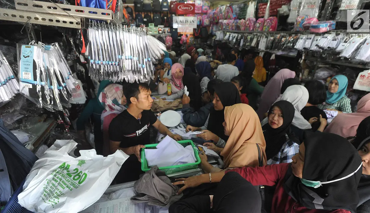 Sejumlah pembeli memilih baju seragam sekolah baru untuk anaknya di salah satu kios di Jalan Pengadilan, Bogor, Rabu (11/7). Menjelang dimulainya tahun ajaran baru, para orang tua disibukan belanja kelengkapan sekolah anak mereka (Merdeka.com/Arie Basuki)