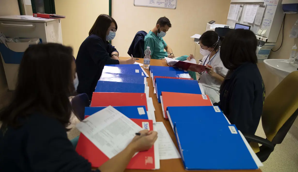 Elisabetta Teti mencatat saat briefing pagi di departemen penyakit menular Rumah Sakit Poliklinik Tor Vergata, di Roma, 7 November 2020. Pada hari Sabtu Teti menangani dua unit perawatan sub-intensif Covid dengan 28 pasien, 18 di antaranya menggunakan helm pernapasan. (AP Photo/Alessandra Tarantino)