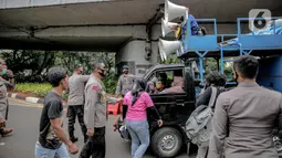 Petugas kepolisian yang berjaga memberhentikan mobil komando aksi di sekitar Gedung DPR, Jakarta, Jumat (14/8/2020). Polda Metro Jaya melarang adanya unjuk rasa di depan Gedung DPR/MPR yang bertepatan dengan sidang tahunan sekaligus pidato kenegaraan Presiden Jokowi. (Liputan6.com/Faizal Fanani)