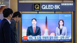 Orang-orang menonton siaran berita yang menunjukkan rekaman file uji coba rudal Korea Utara, di sebuah stasiun kereta api di Seoul, Korea Selatan, Minggu (9/10/2022).  Serangkaian uji coba itu telah memicu peringatan besar-besaran di Amerika Serikat (AS) dan Jepang. (Photo by ANTHONY WALLACE / AFP)