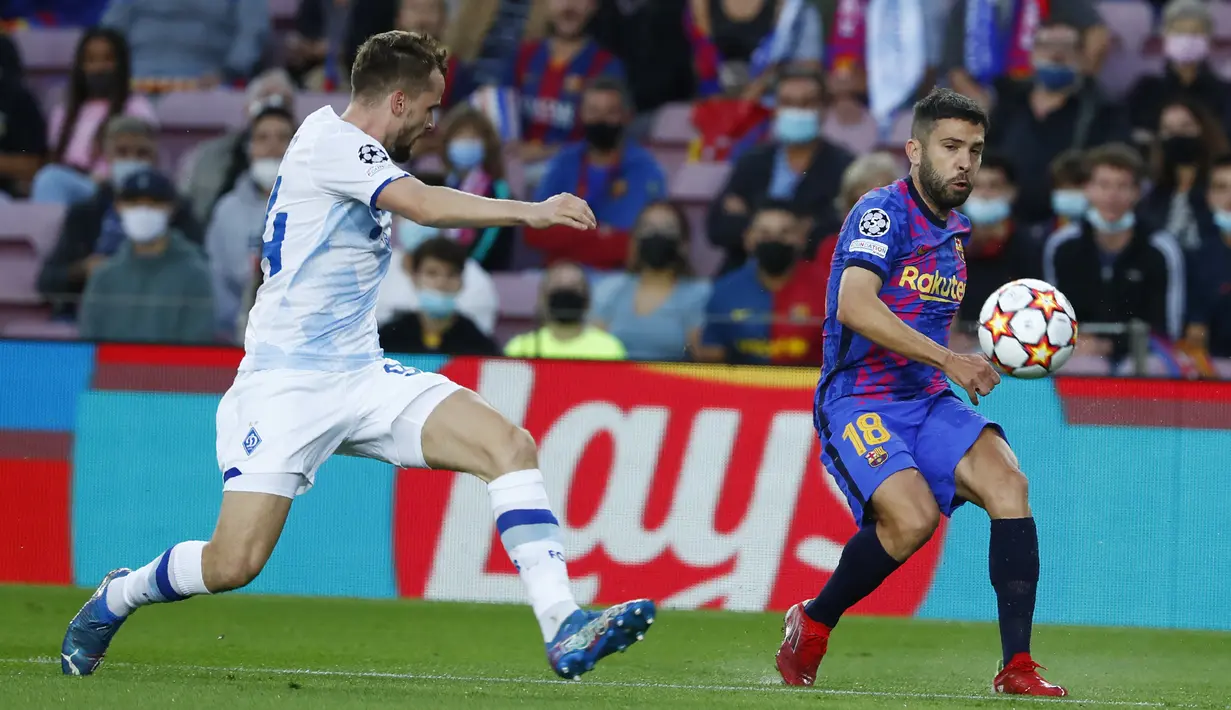 Bek Barcelona, Jordi Alba mengumpang bola dari kawalan pemain Dinamo Kyiv, Tomasz Kedziora pada pertandingan lanjutan Grup E Liga Champions di di stadion Camp Nou di Barcelona, Spanyol, Rabu (20/10/2021). Barcelona menang tipis atas Dinamo Kyiv dengan skor 1-0. (AP Photo/Joan Monfort)