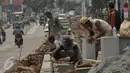 Pekerja saat menyelesaikan proyek rehabilitasi ruas jalan Ciputat-Pamulang, Tangerang Selatan, (28/1). Pemerintah Provinsi Banten akan melakukan rehab pada beberapa titik ruas jalan yang menghabiskan lebih dari Rp 21 miliar. (Liputan6.com/Faisal R Syam)