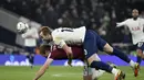 Penyerang Tottenham, Harry Kane berduel memperebutkan bola dengan pemain West Ham, Craig Dawson pada pertandingan perempat final Piala Liga Inggris di Stadion Tottenham Hotspur di London, Kamis (23/12/2021). Kemenangan mengantar Chelsea ke semifinal Piala Liga Inggris. (AP Photo/Rui Vieira)
