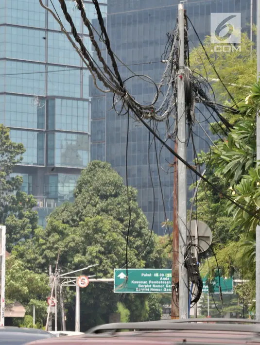 Kondisi kabel listrik yang menjuntai di Jalan Haji Agus Salim, Jakarta, Minggu (9/9). Instalasi kabel yang menjuntai ke jalan akibat tersangkut truk tersebut dapat membahayakan warga dan pengendara yang melintas. (Merdeka.com/ Iqbal S. Nugroho)