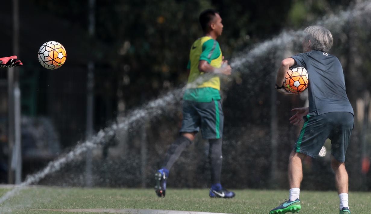Semprotan air melintasi dekat asisten pelatih Miguel Gandia (kanan) saat memberikan instruksi pada sesi latihan Timnas U-22 Indonesia di Lapangan SPH, Karawaci, Jumat (17/3/2017).  (Bola.com/Nicklas Hanoatubun)