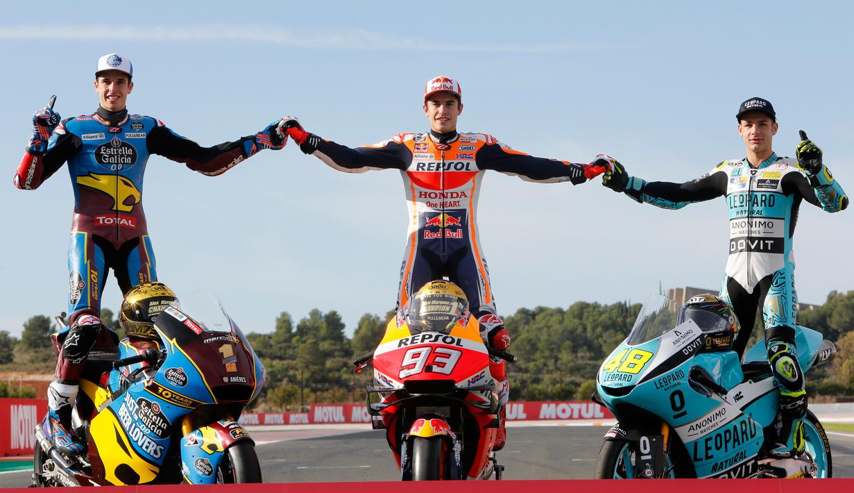 Pembalap MotoGP Marc Marquez (tengah) bersama pembalap Moto2 Alex Marquez (kiri) dan pembalap Moto3 Lorenzo Dalla Porta (kanan) berpose di depan Valencia Motorcycle Grand Prix, Spanyol, Minggu (17/11/2019). Ketiganya sukses merebut gelar juara dunia tahun 2019. (AP Photo/Alberto Saiz)