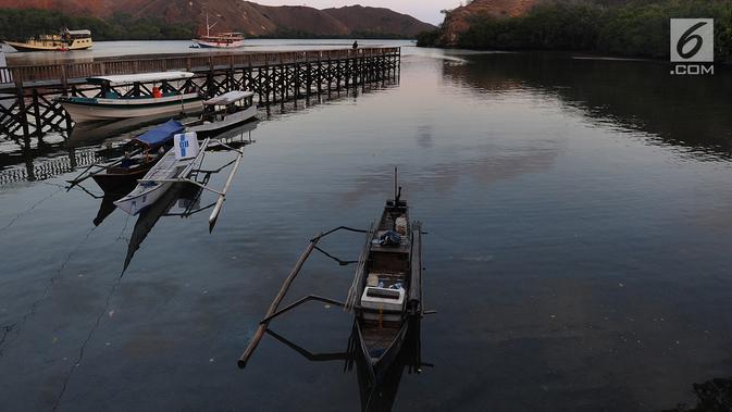 Perahu wisatawan ditambatkan pada sebuah teluk di Pulau Rinca, Taman Nasional Komodo, NTT, Minggu (14/10). Di Pulau Rinca hidup berbagai jenis binatang seperti komodo, babi liar, kerbau dan burung. (Merdeka.com/Arie basuki)