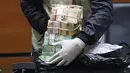 Petugas KPK menunjukkan barang bukti uang saat jumpa pers terkait OTT Bupati Cirebon Sunjaya Purwadi Sastra di Gedung KPK, Jakarta, Kamis (25/10). Sunjaya diduga menerima uang Rp 6,65 miliar terkait jual beli jabatan. (Liputan6.com/Herman Zakharia)