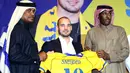 Pemain internasional Belanda, Wesley Sneijder memegang jersey nomor 10 saat diperkenalkan sebagai pemain baru klub Qatar, Al Gharafa, di Doha, Senin (8/1). Mantan gelandang Inter Milan dan Real Madrid itu dikontrak selama 18 bulan ke depan. (STRINGER/AFP)