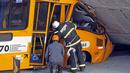 Petugas pemadam kebakaran setempat melihat kondisi sebuah bus angkutan umum yang hancur akibat tertimpa jembatan yang runtuh di di Belo Horizonte, Brasil, (3/7/2014). (AFP PHOTO/Leo Fontes)