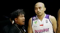 Pelatih Rans PIK Basketball, Koko Heru Setyo Nugroho (kiri) memberikan instruksi kepada Bima Riski Ardiansyah saat melawan Satria Muda Pertamina pada laga IBL 2022 di Hall Basket GBK, Jakarta, Rabu (19/01/2022). Satria Muda menang dengan skor 64-32. (Bola.com/M Iqbal Ichsan)