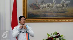 Pembalap F1, Rio Haryanto merapikan baju balap jelang bertemu Wakil Presiden Jusuf Kalla di Istana Wapres, Jakarta, Senin (14/3/2016). Kedatangan Rio untuk meminta restu jelang laga perdana Formula 1, 20 Maret mendatang. (Liputan6.com/Helmi Fithriansyah)