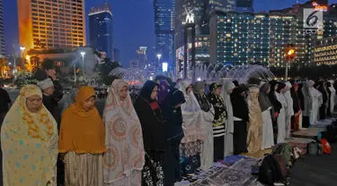 Massa Gerakan Nasional Kedaulatan Rakyat melaksanakan salat magrib di sela aksi unjuk rasa di depan kawasan Bundaran HI, Jakarta, Selasa (21/5/2019). Dalam aksinya, mereka Bawaslu memeriksa hasil Pemilu 2019 yang dinilai banyak terdaopat kecurangan. (Liputan6.com/Herman Zakharia)