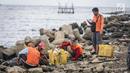 Petugas kebersihan membersihkan sampah laut di Pelabuhan Kali Adem, Jakarta, Senin (1/1). Banyaknya sampah plastik dibandingkan ikan yang gagal dikelola dengan baik membuat limbah yang mengakibatkan laut tercemar.  (Liputan6.com/Faizal Fanani)