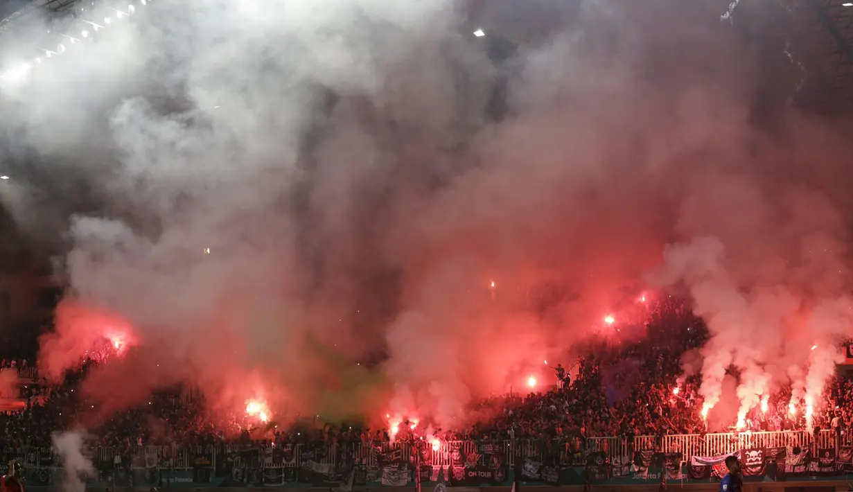 Suporter PSS Sleman menyalakan flare saat melawan Semen Padang pada laga Liga 2 di Stadion Pakansari, Jawa Barat, Selasa (4/12). PSS menang 2-0 atas Semen Padang. (Bola.com/M. Iqbal Ichsan)