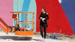 Tarsila Schubert beristirahat sebelum melanjutkan membuat mural di Museum Seni Terbuka, Kota Amman, Yordania, Kamis (29/9). Seniman cantik ini membuat mural untuk mengampanyekan pentingnya pemberdayaan perempuan. (REUTERS/Muhammad Hamed)