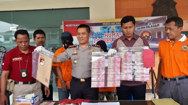 Kapolres Cilacap AKBP Djoko Julianto menunjukkan barang bukti peredaran uang palsu. (Foto: Liputan6.com/Polres Cilacap/Muhamad Ridlo)