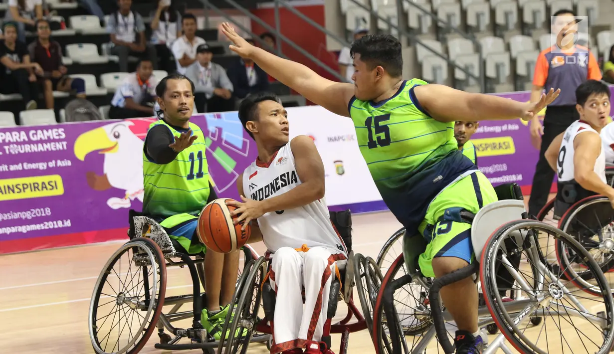 Pebasket difable Indonesia, Gusti Putu P Adriyana berebut bola dengan M Hafiz Ramli (Malaysia) pada laga Indonesia Para Games Invitational Tournament 2018 di Hall A Senayan, Jakarta, Minggu (1/7). Indonesia unggul 54-53. (Liputan6.com/Helmi Fithriansyah)