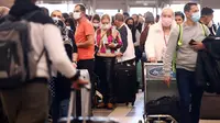 Pelancong berkumpul di terminal internasional Bandara Los Angeles (LAX) di tengah lonjakan kasus varian omicron, Selasa (21/12/2021). AAA memperkirakan lebih dari 109 juta orang Amerika akan melakukan perjalanan selama musim liburan, meningkat 27,7% dari tahun 2020. (MARIO TAMA/Getty Images via AFP)