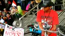 Seorang laki-laki saat mengelar aksi di depan Gedung Komisi Pemberantasan Korupsi (KPK), Jakarta, Senin (16/02/15).  Para pelajar mengayuh sepeda ontel selama 13 hari dari  Jember menuju Jakarta untuk mendukung KPK. (Liputan6.com/Faisal R Syam)