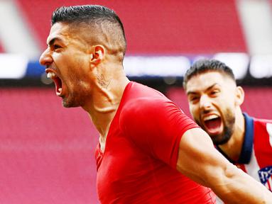 Striker Atletico Madrid, Luis Suarez, melakukan selebrasi usai mencetak gol ke gawang Osasuna pada laga Liga Spanyol di Stadion Wanda Metropolitano, Minggu (16/5/2021). Atletico Madrid menang dengan skor 2-1. (AFP/Gabriel Bouys)