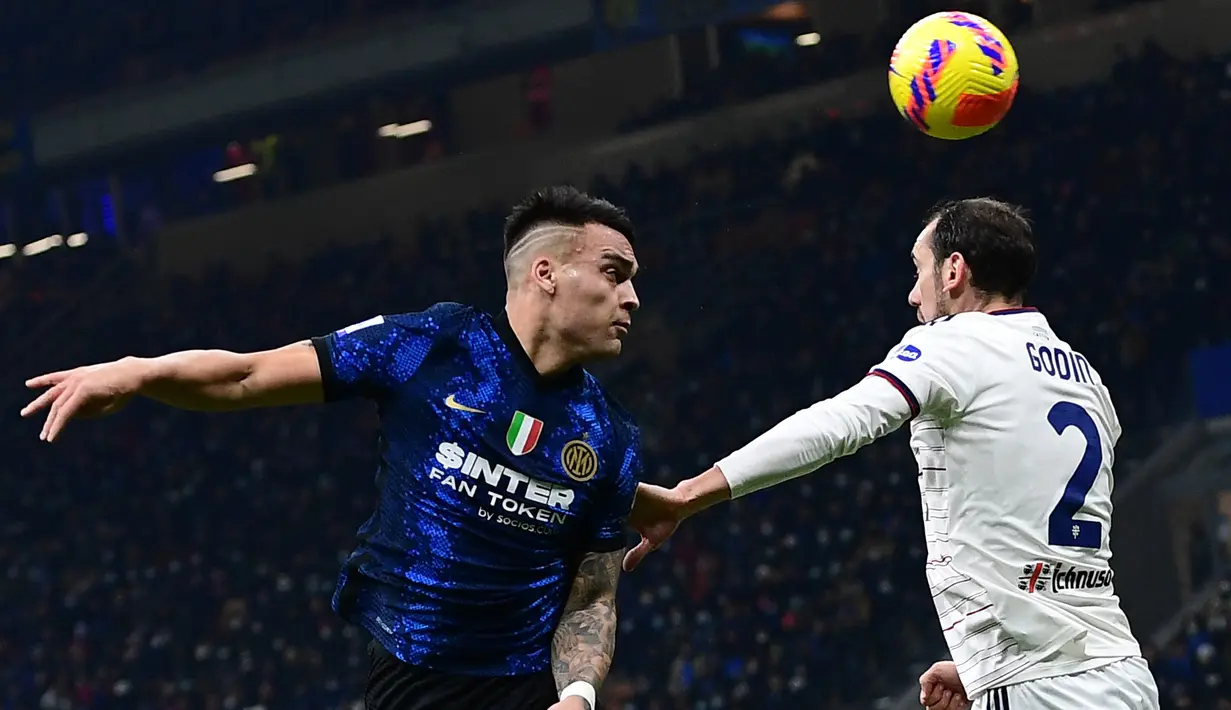Penyerang Inter Milan Lautaro Martinez (kiri) menyundul bola melewati bek Cagliari Diego Godin pada laga lanjutan Liga Italia pekan ke-17 di Guseppe Meazza, Senin dini hari WIB (13/12/2021). Inter Milan menang telak 4-0 atas tim tamu Cagliari. (Miguel MEDINA / AFP)