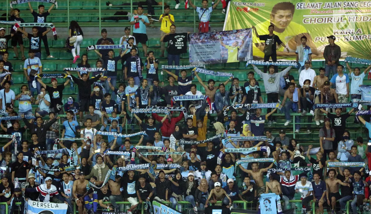 Suporter Laskar Joko Tingkir membentangkan syal dan poster bergambar alm Choirul Huda saat menyaksikan laga Persela melawan Bhayangkara FC di Stadion Patriot Candrabhaga, Bekasi, Jumat (27/10). (Liputan6.com/Helmi Fithriansyah)