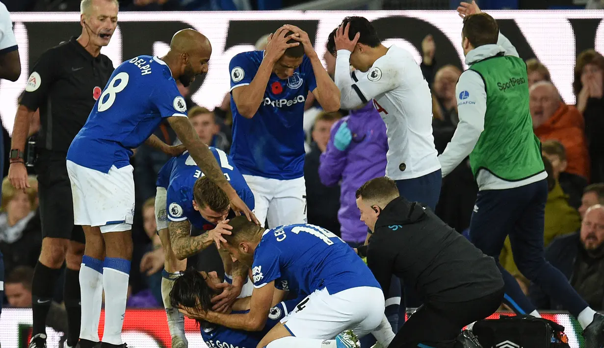 Gelandang Everton Andre Gomes (tengah bawah) dikerubuni teman-temannya setelah ditekel striker Tottenham Hotspur Son Heung-min (tengah atas) pada pertandingan Liga Inggris di Goodison Park, Liverpool, Inggris, Minggu (3/11/2019). Tekel Son Heung-min menyebabkan Andre Gomes patah kaki. (Oli SCARFF/AF